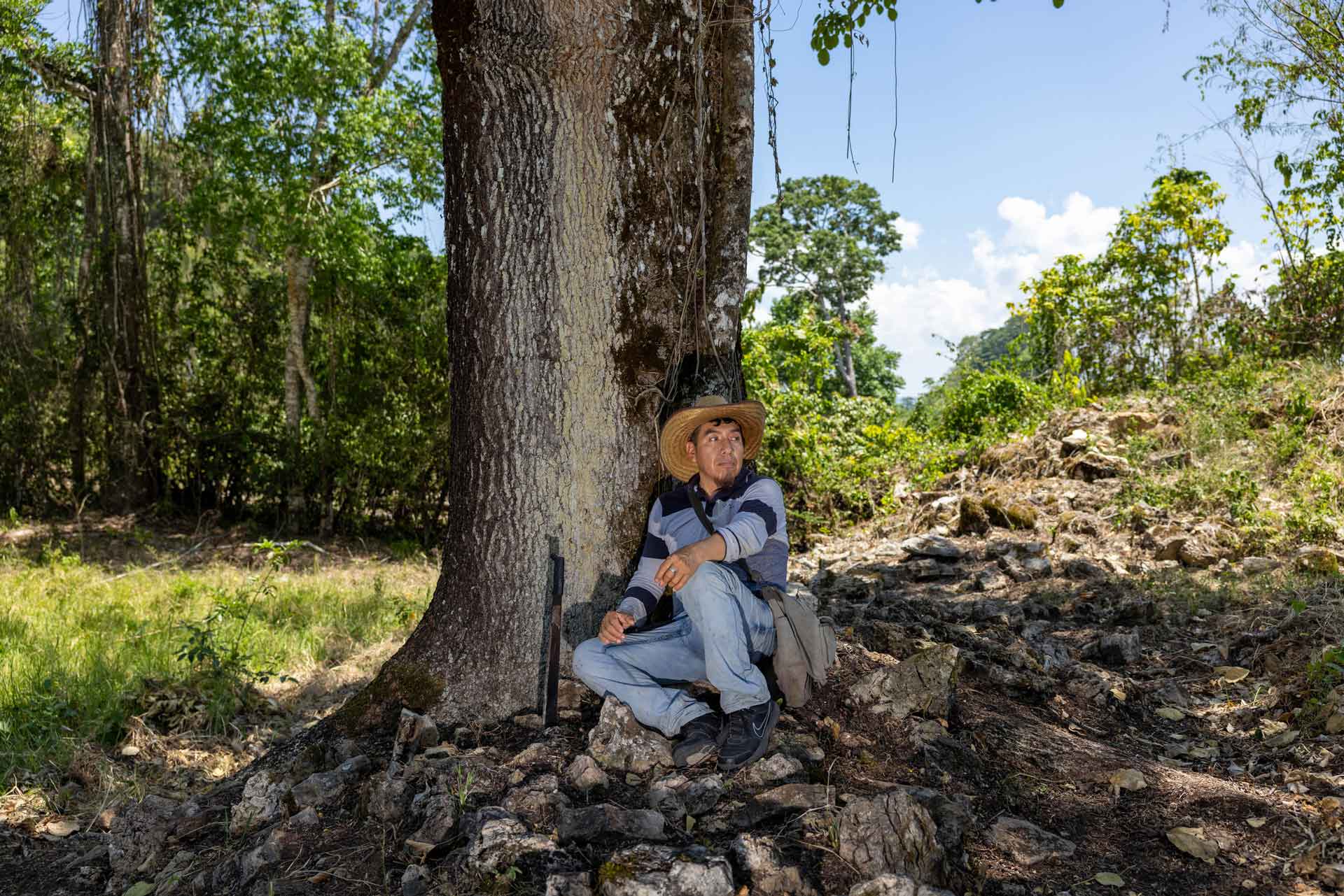 Jacinto leans up against a tree in the shade