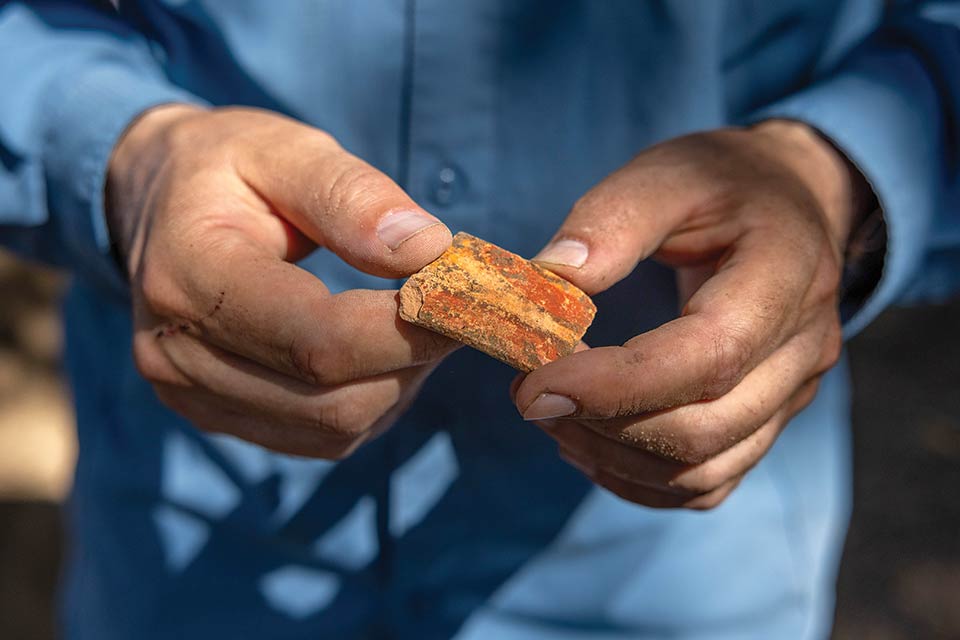 Close up of hands holding an ancient object