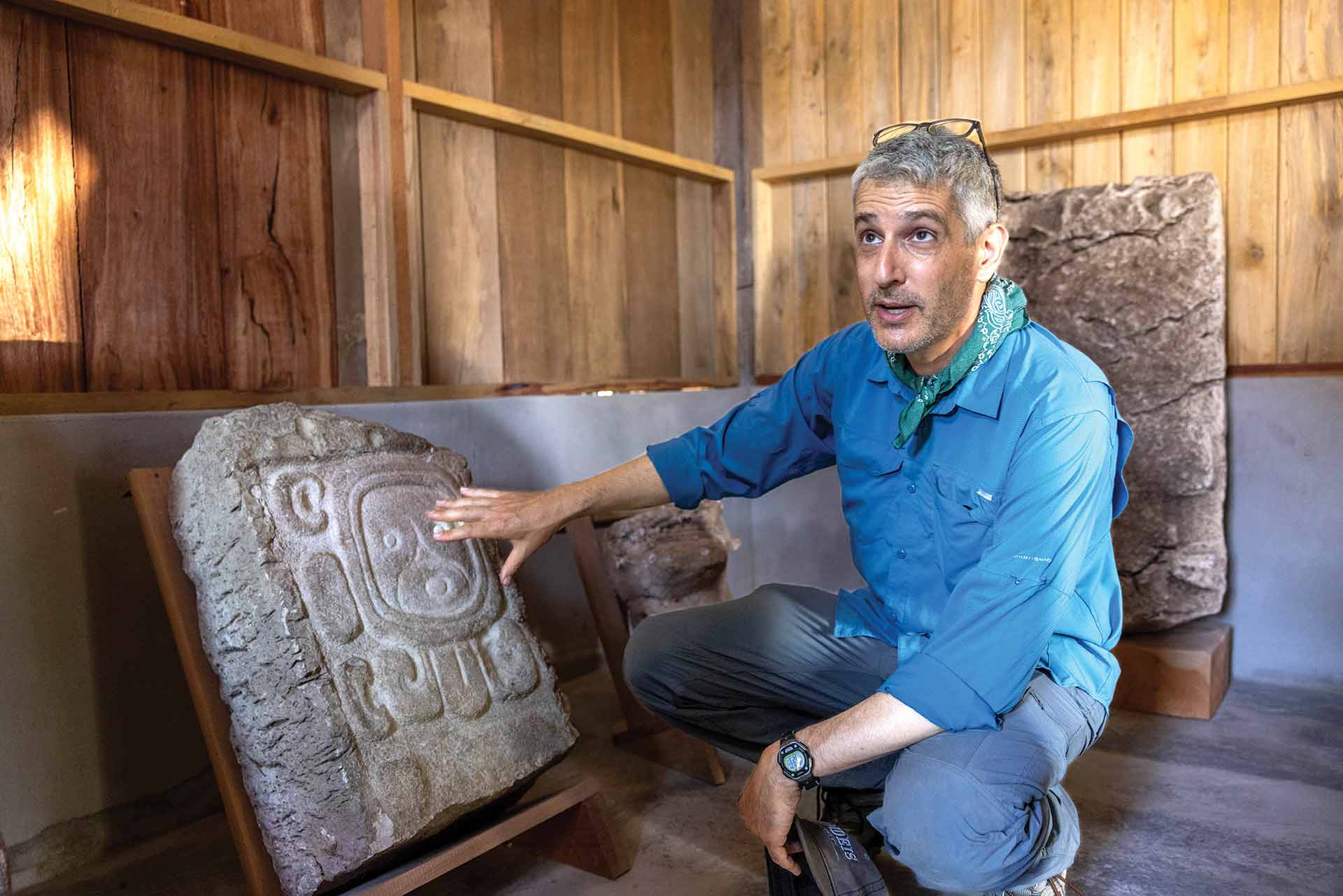 Charles Golden with his hand on a stelae panel