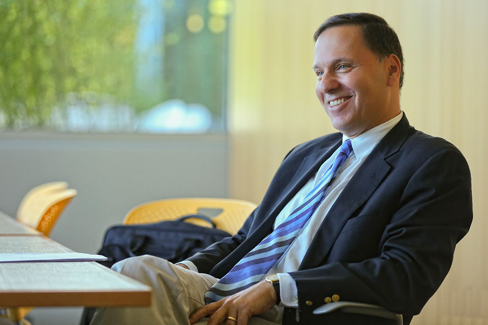 President Ronald D. Liebowitz smiling and leaning back in a chair at a table.
