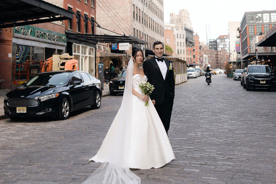 A bride and groom stand together in the street in New York City.