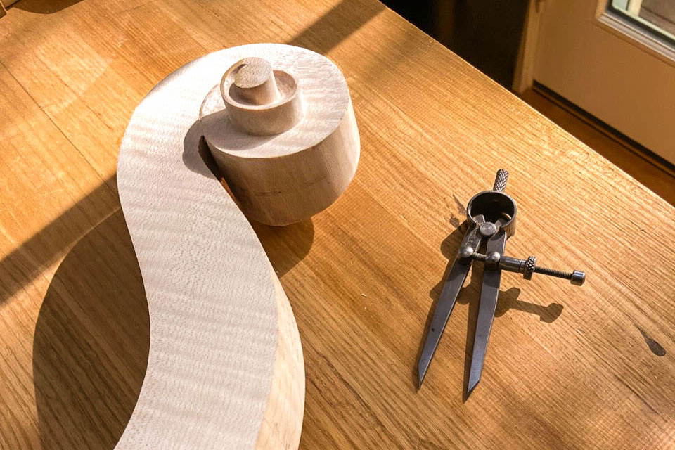 A carefully carved wooden cello's scroll.