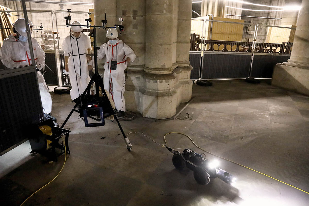 A robot on wheels is seen on the floor near Katz's team