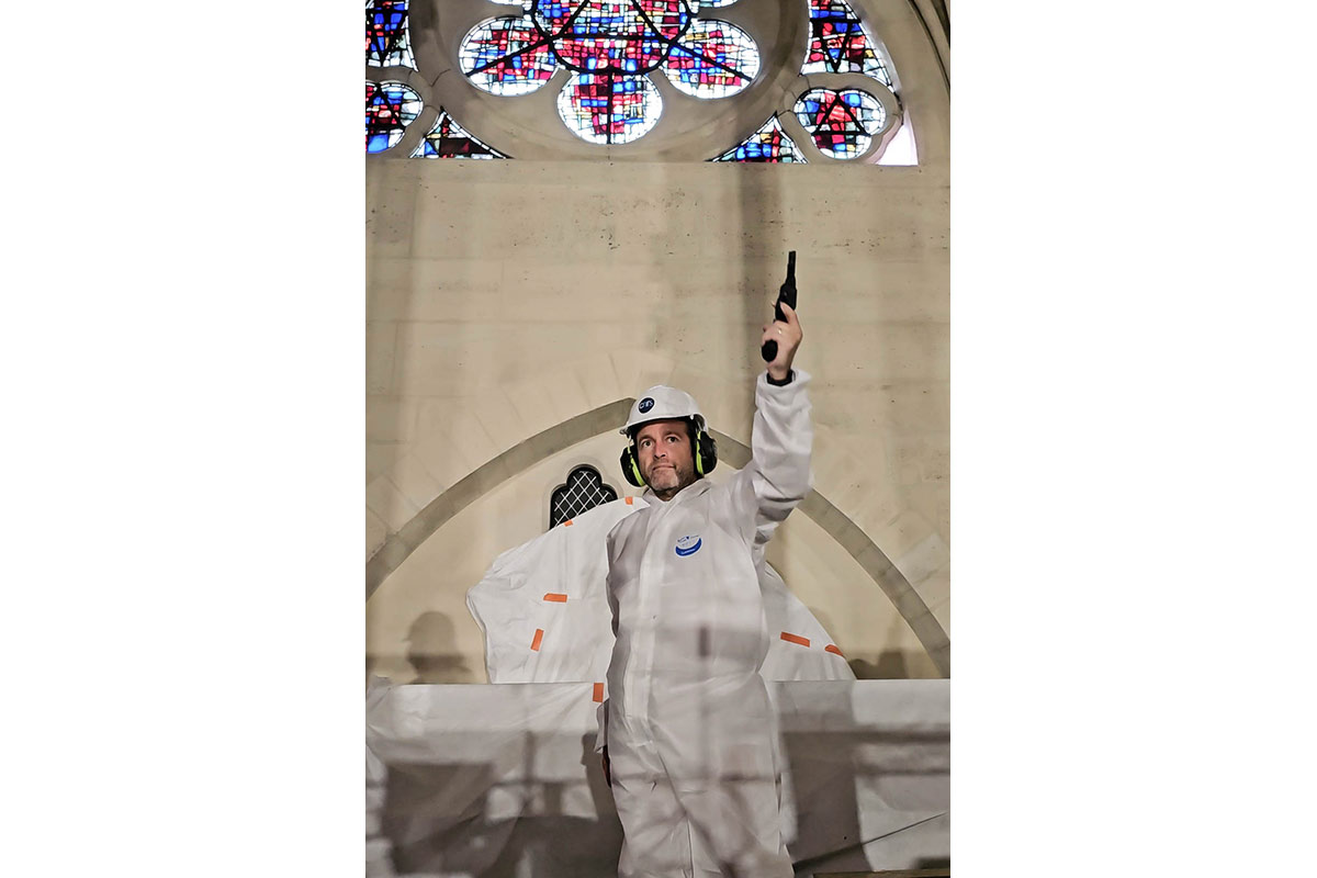 Brian Katz holding a starter pistol in the air inside Notre Dame