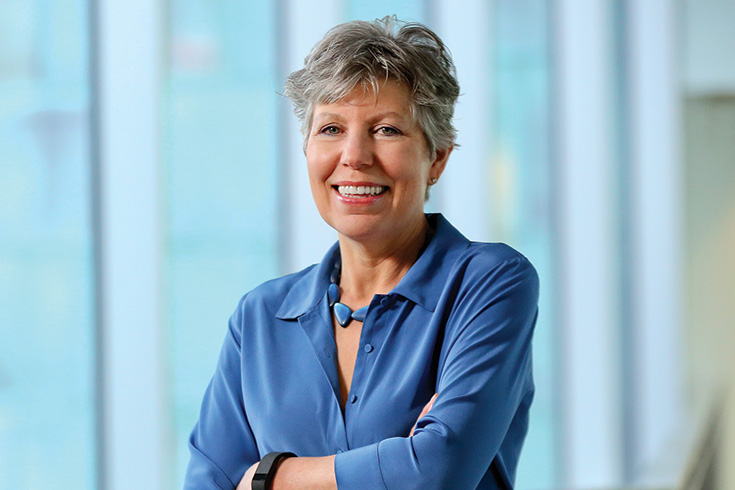 Laura Gardner smiling at the camera with her arms crossed