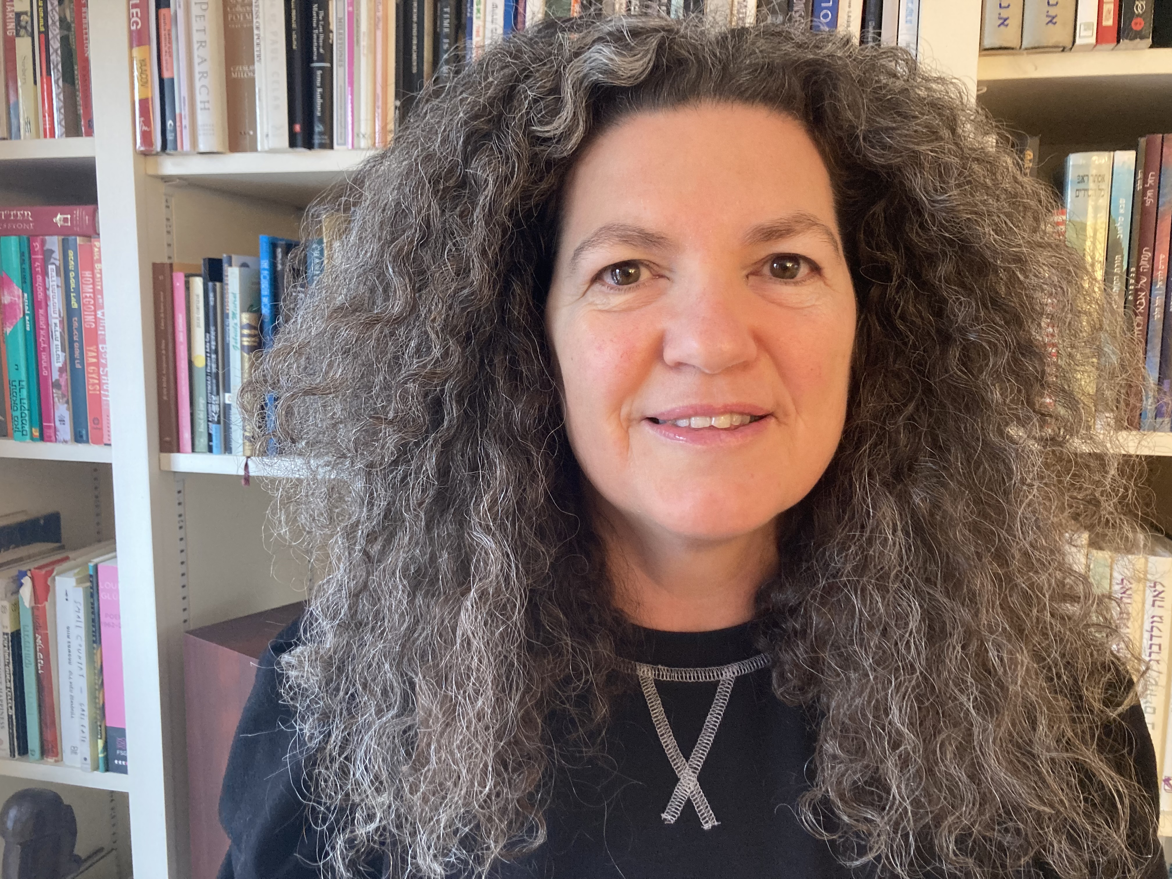 Photo of Ilana Szobel in front of bookshelf