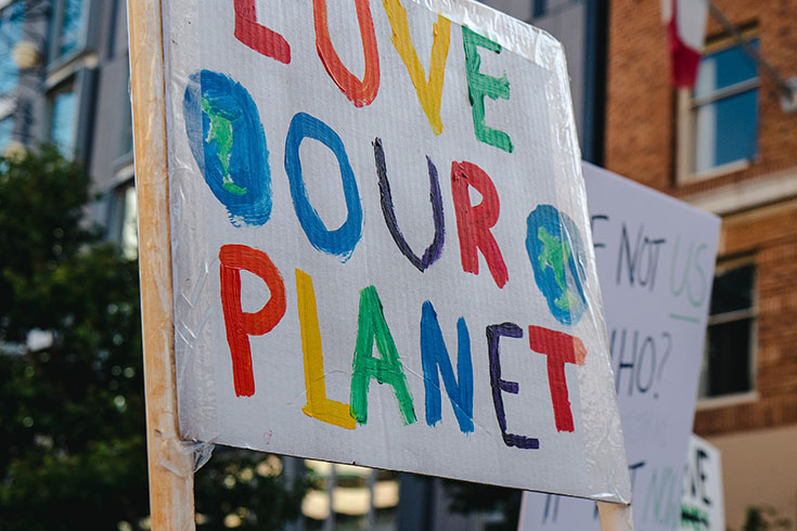 A sign at a protest that reads, "Love Our Planet."