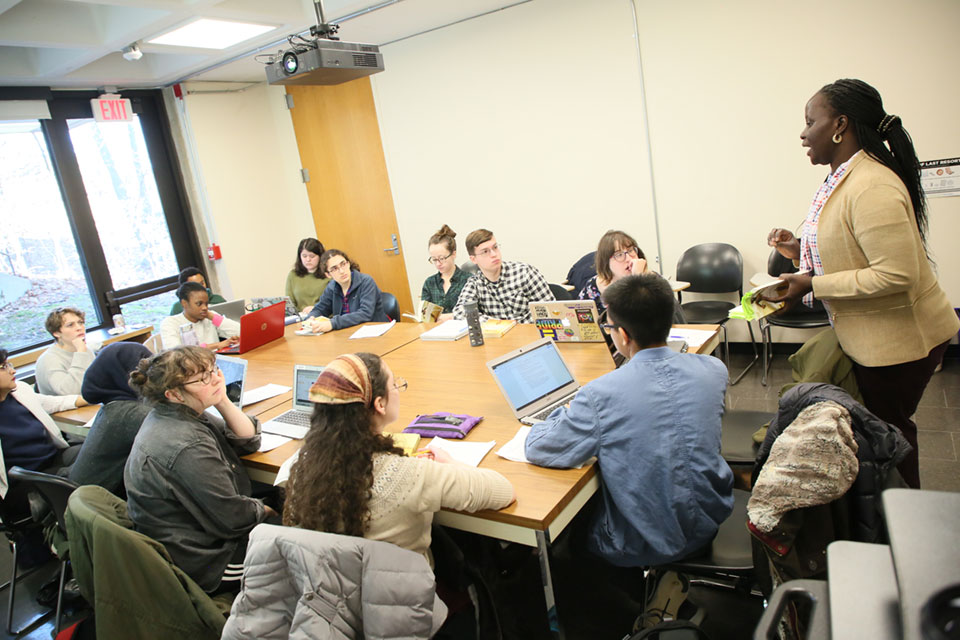 Emilie Diouf teaches students who are sitting around a table.