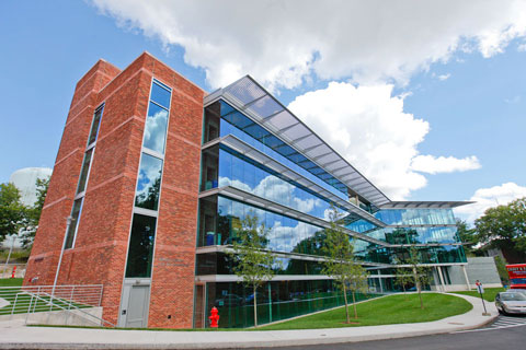 External photo of the Mandel Center front facade and lush green lawn on a mostly sunny day.