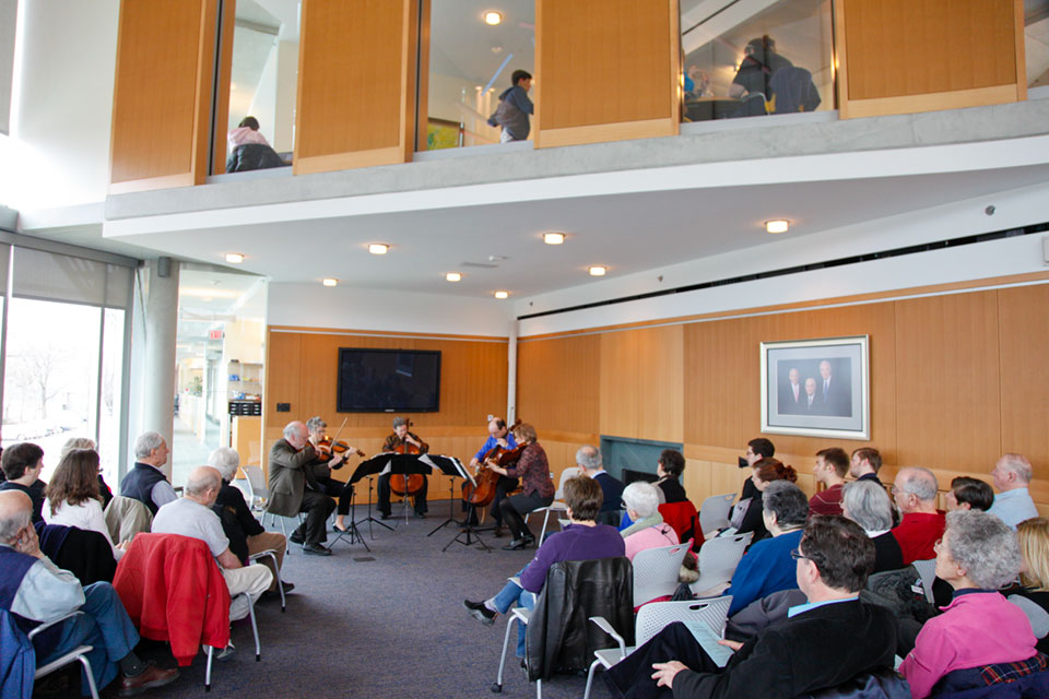 Audience watches musicians playing string instruments