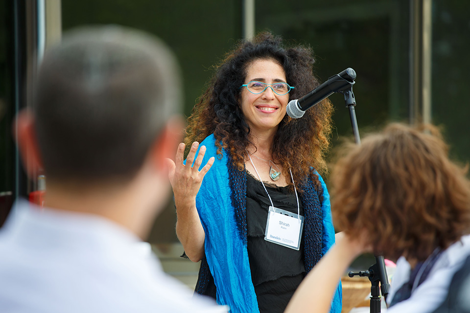 Speaker at a mic addressing a group.