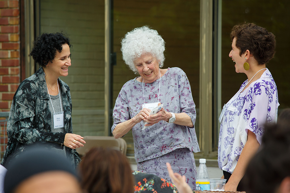 Three women sharing their artwork.