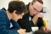 Two adults studying a text