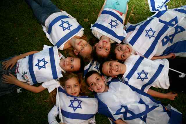 Kids laying in a circle with Israeli flags