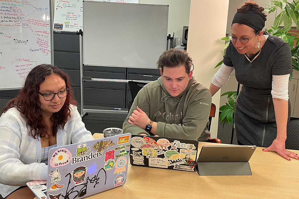 Posed picture of Prof. Ziva Hassenfeld and 2 Scroll Lab participants around a table in the lab.