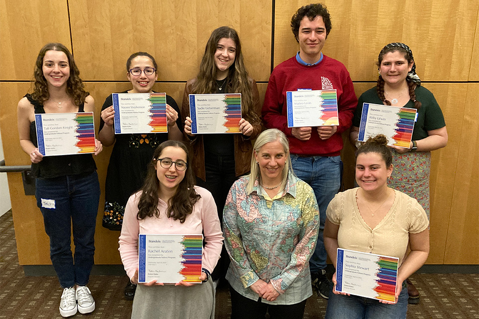 A group of 7 students holding certificates with their teacher