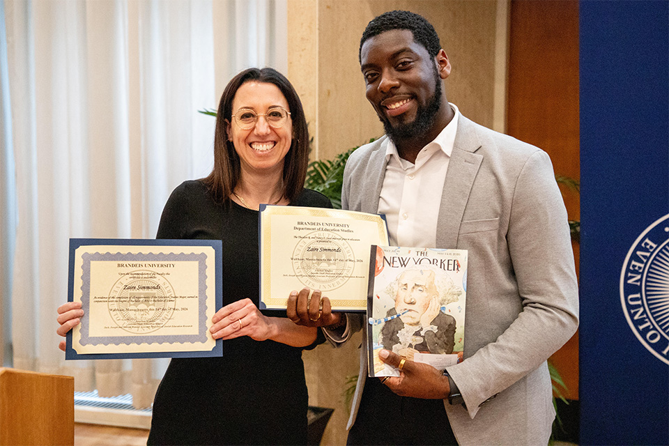 Ziva and Zaire Simmonds holding diplomas after thesis defense presentation.
