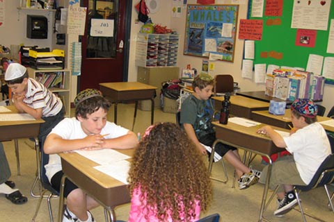 Students working in pairs at tables where they face each other.