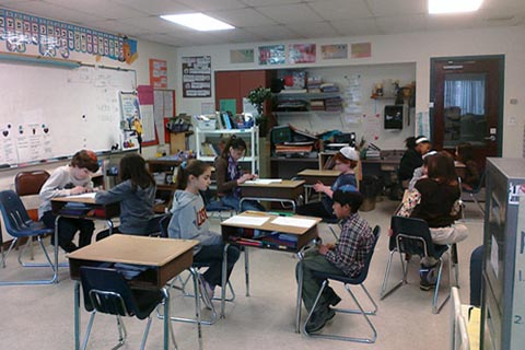 A long view of the classroom with the students working in pairs.