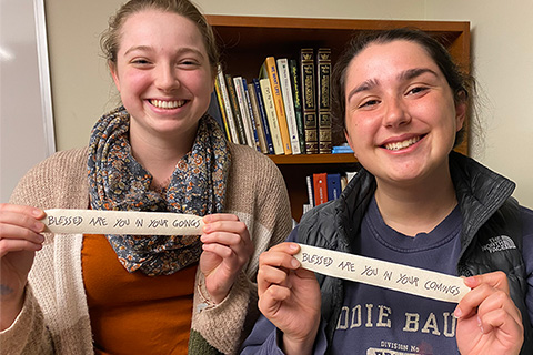 Two students holding up artwork