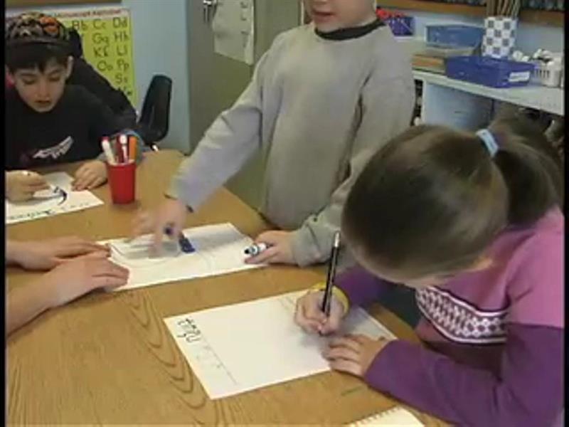 Kids sitting a desk, writing