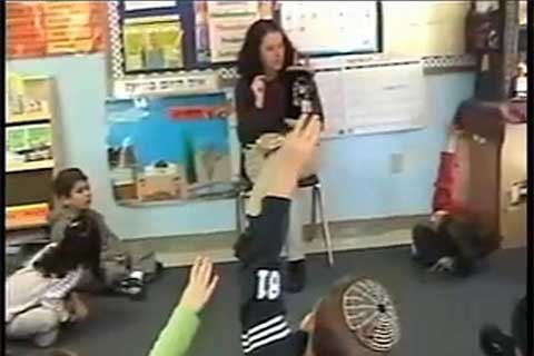Shira Horowitz sits and speaks to young children in a classroom