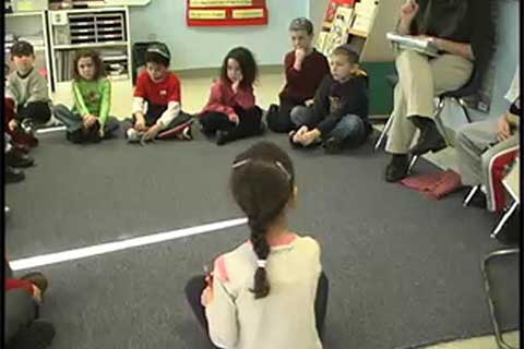 Children sit in a circle on the floor