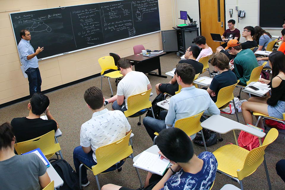 professor teaching college level math in a classroom full of students