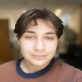 Head shot of Maddie Silverberg smiling in striped orange and blue shirt