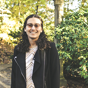 Anya in a black blazer, smiling at the camera on Wellesley College Campus
