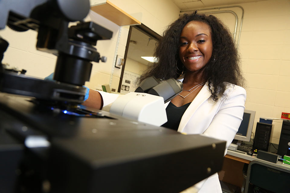 Angela Berry at a microscope