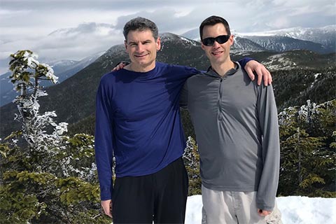 2 participants on a hike in the snow-covered White Mountains