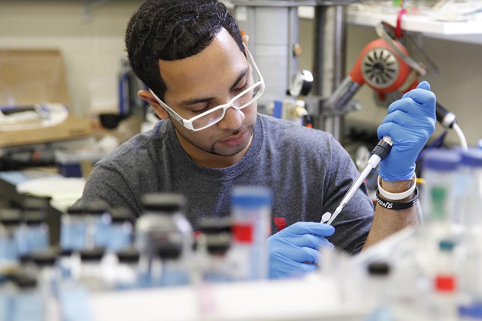 Student working in a lab with pipette