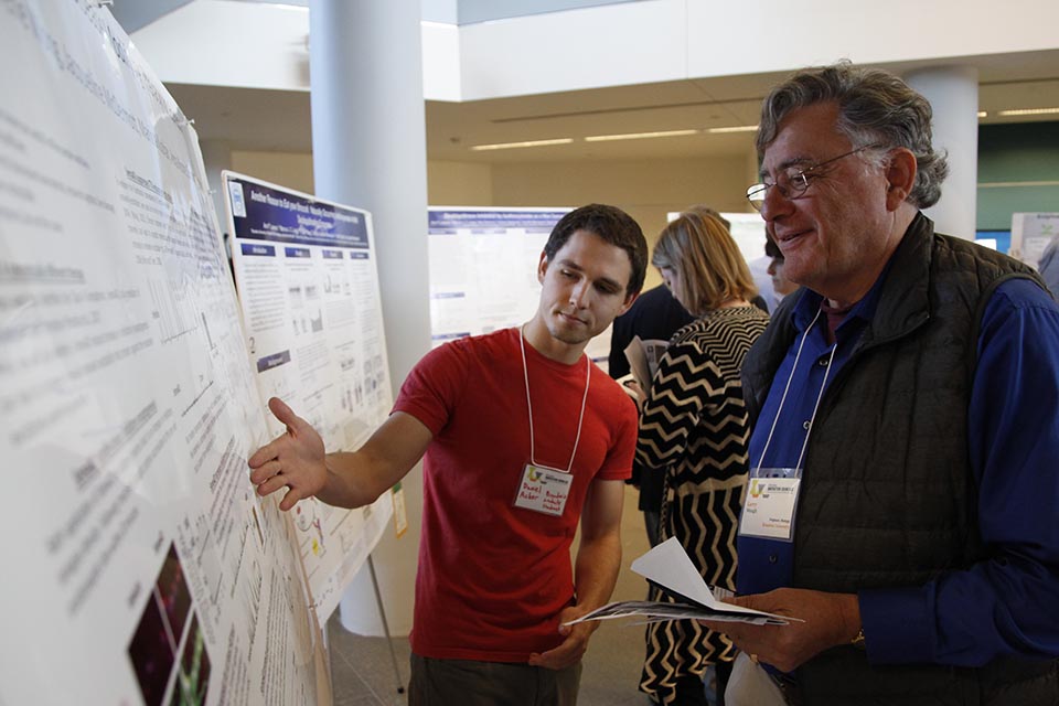 Student presenting his research at a poster session,