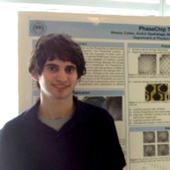 Wesley Cohen standing in front of poster entitled "PhaseChip Trajectories."