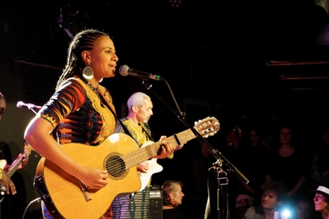 Sona Jobarteh in performance playing the guitar
