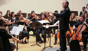 Members of the Brandeis Wellesley Orchestra rehearse with conductor Neal Hampton