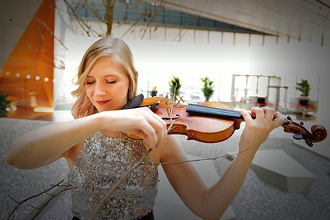 Julia Glenn plays the violin in an atrium