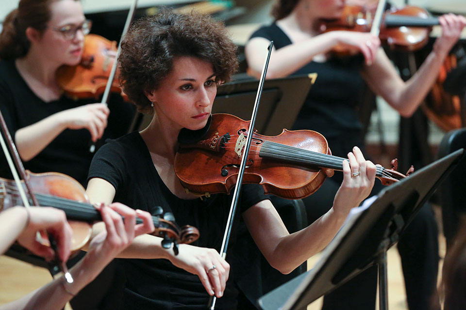 A woman plays the violin in a performance