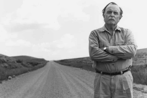 Alvin Lucier poses in front of an empty road