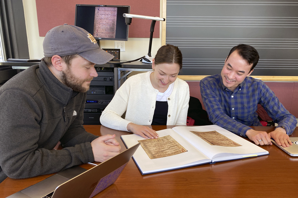 Students reviewing music in a book