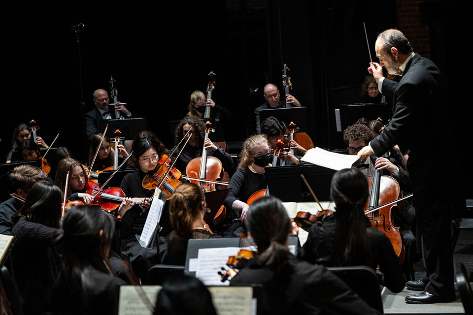The Brandeis-Wellesley Orchestra performs on stage.
