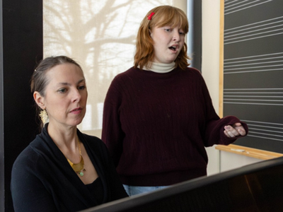A vocal instructor works with a student