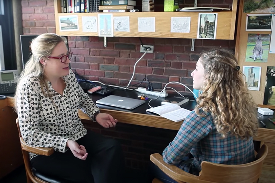 Georgia Luikens sits in an office and speaks to another student