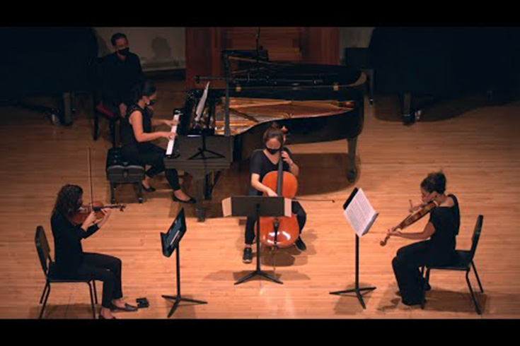 Students on stage playing various sting instruments.