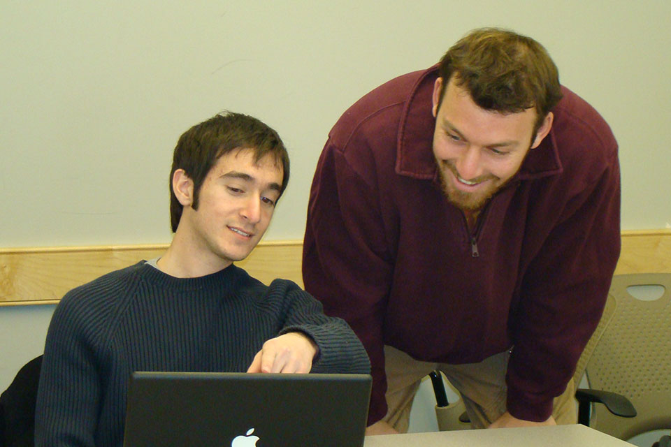 Two students looking at laptop screen