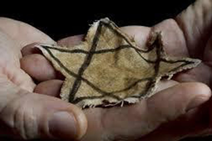 Zoomed in picture of a person holding a fabric cut out of the Star of David.