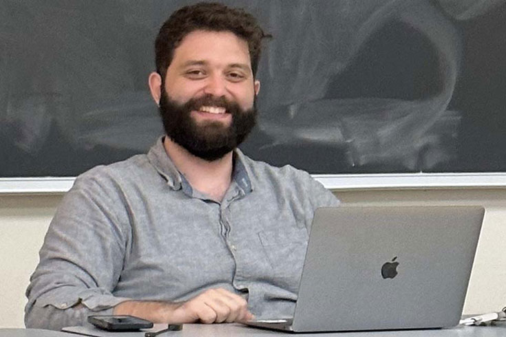 Mike Vivian sitting at a desk with his laptop.