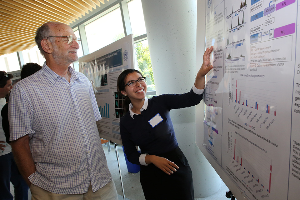 A student presents her poster to a faculty member at SciFest 2018