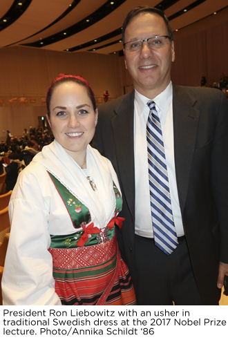 Brandeis President Ron Liebowitz with an usher, dressed in traditional Swedish garb, at the 2017 Nobel Prize lecture. Photo/Annika Schildt '86